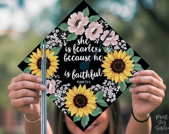 May include: Black graduation cap decorated with sunflowers, white flowers, and green leaves. The cap has the text "She is fearless because he is faithful. Psalm 13:4."