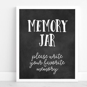 May include: A white ceramic mug with a black handle and the text "But First, Coffee" in a black, handwritten-style font. The mug is on a white surface.