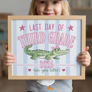 Könnte beinhalten: Ein gerahmter Druck mit dem Text "LAST DAY OF THIRD GRADE 2026 see you later!" zeigt ein Cartoon-Alligator mit einer rosa Schleife. Der Hintergrund hat blaue und weiße Streifen mit rosa Sternen und Herzen.