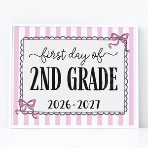 Può includere: Un cartello rettangolare con sfondo a righe verticali rosa chiaro e bianco. Un rettangolo centrale bianco con bordo nero smerlato contiene il testo nero: first day of 2ND GRADE 2026-2027. Due fiocchi rosa sono posizionati agli angoli.