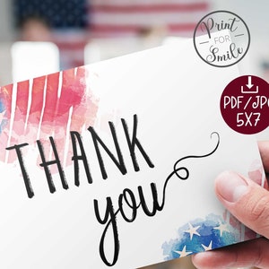 May include: A white card with a watercolour design of the American flag. The card says "Thank you" in black script.