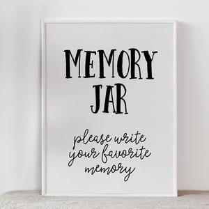 May include: White sign with black text that reads "MEMORY JAR" and "Please write your favourite memory".