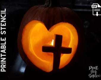 May include: A pumpkin carved with a heart and cross design, illuminated from within. The warm glow highlights the shape. Text on the left says "PRINTABLE STENCIL," and the bottom right corner has the text "Print For Smiles."