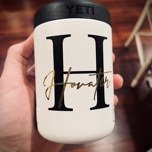 May include: White Yeti Rambler with a black letter "H" and the name "Howard" written in gold script.