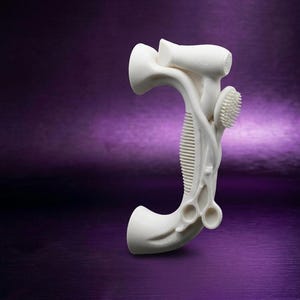 May include: A white, three-dimensional sculpture shaped like the letter J, featuring integrated hair styling tools including a hair dryer, a round brush, a comb, and a pair of scissors, all moulded into a single, cohesive, matte-finished object.