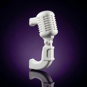 May include: A matte white, three-dimensional letter J shaped like a vintage microphone. The top portion features the classic ribbed grill of a microphone, while the lower section forms the base of the letter with a smooth, solid finish.