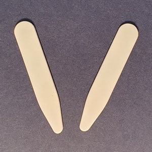 Puede incluir: Cinco soportes para cuellos, dos blancos, dos grises y uno negro. Los soportes para cuellos están hechos de plástico y tienen un acabado liso y pulido.