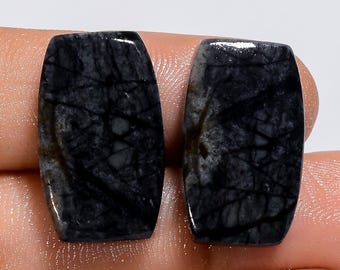 May include: Two black and white rectangular cabochons with a marbled pattern. The cabochons are smooth and polished.