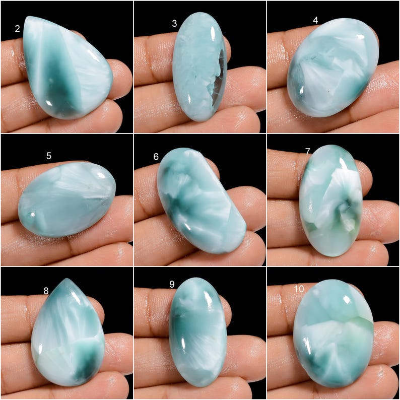 May include: Ten oval-shaped cabochon gemstones with a blue and white marbled pattern. The stones are arranged in three rows of three, with one stone in the center row. The stones are all approximately the same size and shape.