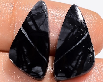 May include: Two black and white triangular shaped cabochons of black and white stone. The stone has a marbled pattern.