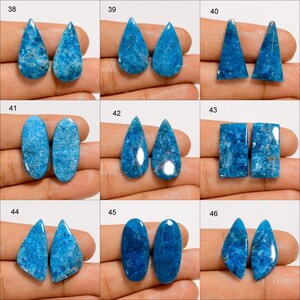 Puede incluir: Una colecci&oacute;n de nueve pares de piedras preciosas de apatita azul pulidas en varias formas. Las piedras preciosas se muestran sobre un fondo neutro, mostrando su color vibrante y texturas &uacute;nicas. Las formas incluyen gotas, tri&aacute;ngulos, &oacute;valos y rect&aacute;ngulos.