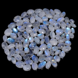 May include: A collection of oval-shaped moonstone cabochons in various sizes. The stones are a milky white color with a blue iridescent sheen.