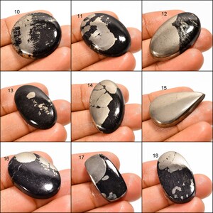 May include: Nine oval and teardrop shaped cabochons of black and silver pyrite, with varying patterns and sizes.