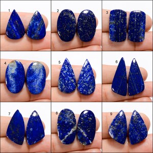Op de afbeelding: Negen paar blauwe lapis lazuli cabochons, elk paar heeft een andere vorm en maat. De cabochons zijn in een rasterpatroon op een witte achtergrond geplaatst.
