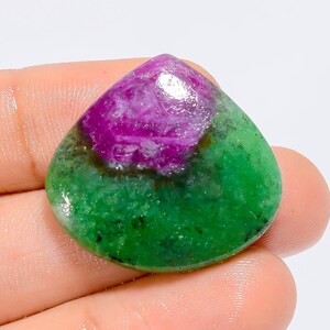 Può includere: Un cabochon di pietra preziosa verde e rosa a forma di lacrima. La pietra preziosa ha una base verde con un centro rosa.