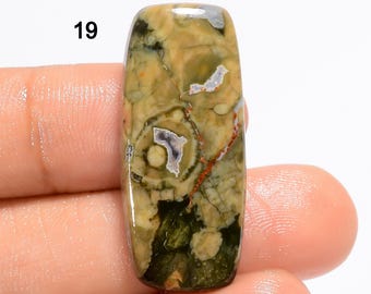 May include: A green, brown, and white patterned stone cabochon with a number 19 printed above it.