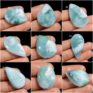 May include: Nine cabochon gemstones, each with a unique pattern of white and blue, are displayed on a hand. The gemstones are labeled with numbers 38 through 46.