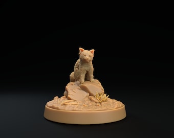Könnte beinhalten: Eine kleine, braune, pelzige Tierfigur, die auf einem Felsen sitzt. Die Figur steht auf einem runden Sockel mit einer strukturierten Oberfläche.