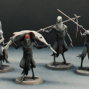 Può includere: Quattro figurine dipinte di creature simili a uccelli con corpi umani. Una figura porta un pesce, un'altra tiene una lancia e altre due tengono lance. Le figurine sono dipinte in tonalità di grigio e rosso.