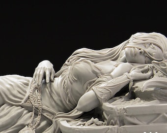 May include: A detailed sculpture of a reclining figure with a blindfold, draped in flowing garments. The figure holds a beaded chain and rests on a stone base. The sculpture is a light, neutral color, with intricate details.