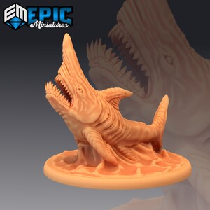 May include: A 3D printed miniature of a monstrous shark with a wide open mouth and sharp teeth. The shark is painted in a light orange color and is standing on a circular base.