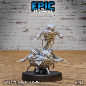May include: A set of four gray, robot miniatures, standing on a black base. The robots are connected by a single, curved, gray piece. The robots have round heads with a single eye and a small, round mouth. The robots have four legs each. The base is labeled "BASE SIZE: SMALL (19.13MM)" and "#4782".