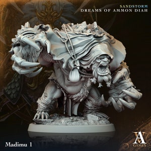 Op de afbeelding: Een grijs, gedetailleerd miniatuurfiguur van een wezen met een grote, open mond, scherpe klauwen en een kap. De figuur staat op een ronde basis en is gelabeld "Madimu 1".