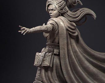 May include: A detailed sculpture of a woman in a flowing cape, looking over her shoulder with an outstretched arm. The figure has long hair pulled back in a high ponytail, and wears a detailed outfit with pouches and armor. The sculpture is a neutral color.