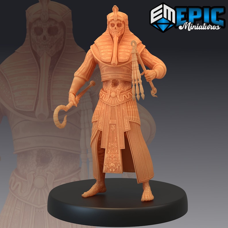 May include: A detailed miniature figurine of a skeletal figure wearing a golden Egyptian headdress and a long, intricately patterned robe. The figure holds a staff with a curved top and a whip in its other hand.