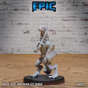 May include: A gray, unpainted miniature figurine of a lizard-like creature holding a sword and shield. The miniature is standing on a black base. The base size is medium (25.5mm). #4975
