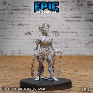 May include: A gray, detailed miniature of a female figure with a crown of thorns, wearing armor and holding chains. The miniature is standing on a black base.  BASE SIZE: MEDIUM (25.5MM) #5113