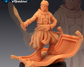 May include: A miniature figurine of a man in a brown tunic and pants, holding a sword, standing on a flying carpet. The carpet is orange and has tassels on the ends. The figurine is painted in a light brown color.