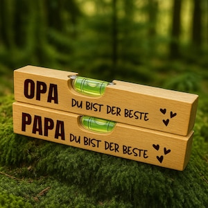 Puede incluir: Dos niveles de madera con un nivel de burbuja verde. El nivel superior dice "OPA DU BIST DER BESTE" y el nivel inferior dice "PAPA DU BIST DER BESTE".