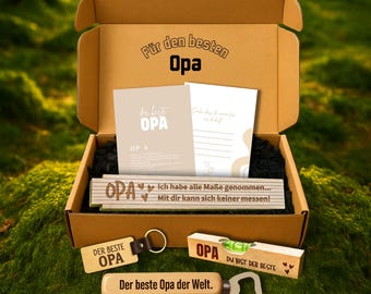 May include: A gift box with the words "Für den besten Opa" printed on the inside lid. The box contains cards, a keychain, a bottle opener, and a level tool, all with the word "Opa" on them. The box is sitting on a bed of green moss.