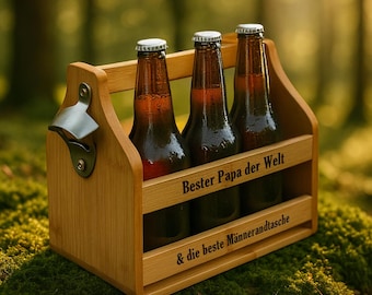 May include: A wooden beer caddy holding three brown glass bottles with silver bottle caps. The caddy has a built-in bottle opener and the text "Bester Papa der Welt & die beste Männertasche" is engraved on the front.