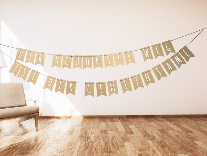 May include: A brown burlap banner with white text that reads "Der sch&ouml;nste Weg ist der gemeinsame" hanging on a white wall.