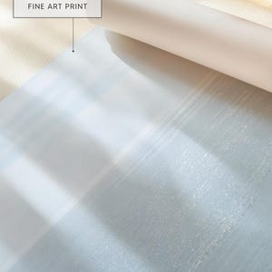 May include: A rolled-up white fine art print with the text "GALLERY QUALITY FINE ART PRINT" in a white box. The print has a light blue and white abstract design.