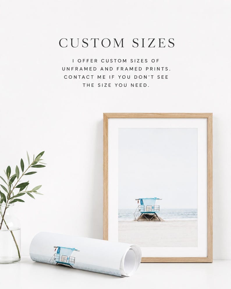May include: A framed print of a lifeguard tower on a sandy beach with a light blue roof. A rolled print with the same image is in front of the frame. Text at the top says "CUSTOM SIZES".