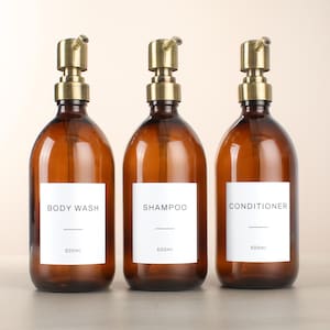 Juego de 3 champús y acondicionadores de gel de ducha en botella de vidrio ámbar. Dispensador marrón rellenable con bomba y etiqueta blanca impermeable. Ecológico.