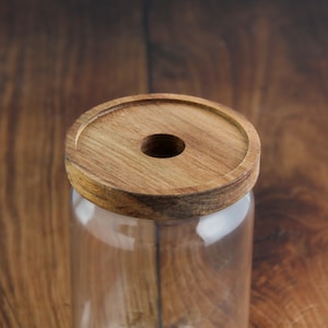 以下が含まれることがあります： 木製の蓋が付いた透明なガラス瓶。蓋の中央に穴が開いています。