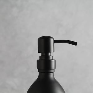 May include: A black soap dispenser with a pump top and a sleek, modern design.