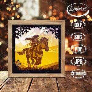 Puede incluir: Una obra de arte enmarcada que presenta una silueta de una persona montada a caballo en un paisaje. La obra de arte está en tonos marrones y amarillos, con un borde negro y un marco de madera. La imagen incluye el texto "Lumibox" e iconos de tipo de archivo.