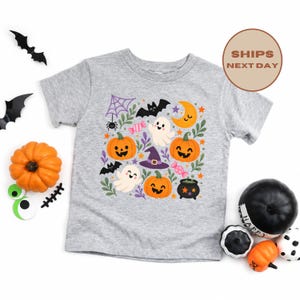 Puede incluir: Una camiseta gris jaspeado de manga corta con un estampado gr&aacute;fico colorido de tem&aacute;tica de Halloween. El dise&ntilde;o incluye calabazas sonrientes, fantasmas blancos, un sombrero de bruja morado, un murci&eacute;lago negro, una telara&ntilde;a, una luna y dulces.