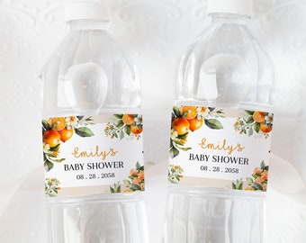 May include: Two clear plastic water bottles with orange and green floral labels. The labels say "Emily's Baby Shower" with the date "08.28.2058".