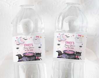 May include: Two clear plastic water bottles with labels featuring a pink and purple Halloween theme. The labels have a ghost, a cauldron, a black cat, and the text "Emily's Baby Shower Oct. 29, 2023".