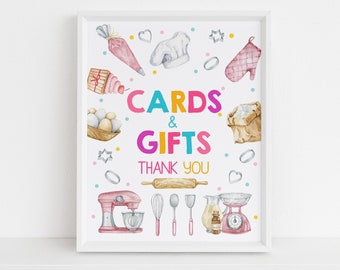 Könnte beinhalten: Ein weißer Rahmen mit einem bunten Schild, auf dem "Karten & Geschenke Danke" steht. Das Schild ist mit Aquarell-Illustrationen von Backutensilien verziert, darunter ein Mixer, ein Nudelholz, Messbecher und eine Kochmütze.