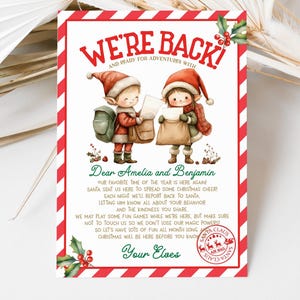 Könnte beinhalten: Eine Weihnachtskarte mit rot-weiß gestreiftem Rand. Die Karte zeigt zwei Elfen-Illustrationen mit roten Hüten, die Briefe halten. Der Text enthält "We're Back!" und eine Nachricht an Amelia und Benjamin von ihren Elfen.