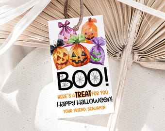 May include: Halloween gift tag with watercolour illustrations of candy bags and carved pumpkins. The tag says "BOO! Here's a TREAT for you Happy Halloween!" with a name at the bottom. The tag is attached with a brown string.