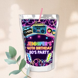 Può includere: Una scatola di succo argentata con un tema anni '80 al neon. La scatola presenta un giradischi, un nastro di cassette e un'auto. Il testo sulla scatola recita "Jennifer's 40th Birthday 80's Party".