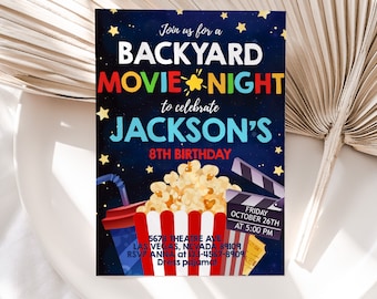 May include: A blue and white invitation for a backyard movie night to celebrate Jackson's 8th birthday. The invitation features a cartoon image of popcorn, a movie clapperboard, and a red and white striped cup with a straw. The text on the invitation reads "Join us for a Backyard Movie Night to celebrate Jackson's 8th Birthday." The date and time of the event are listed as "Friday, October 26th at 5:00 PM". The address is listed as "5678 Theatre Ave, Las Vegas, Nevada 89109". The RSVP information is "RSVP Anna at 123-4567-8909". The invitation also states "Dress pajama!"